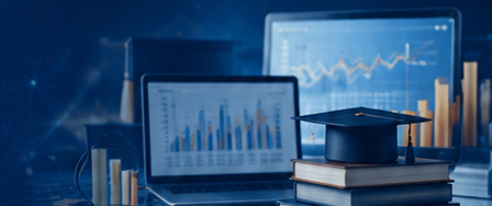 Laptops showing data analytics charts beside a stack of research books topped with a graduation cap